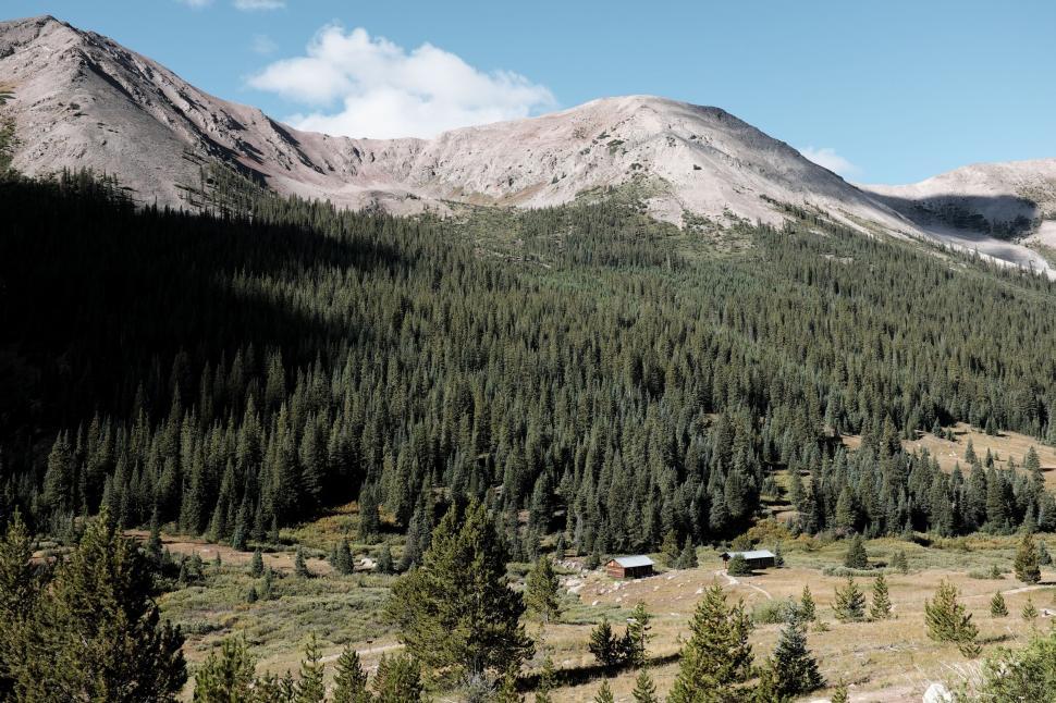 Free Image of Mountain Range With Cabin in Foreground 