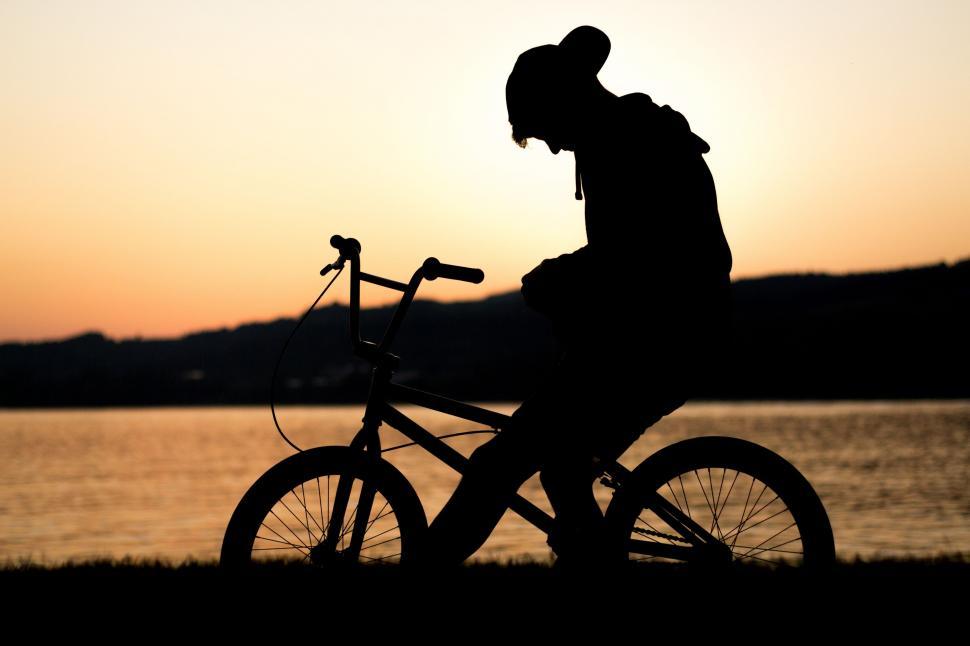 Free Image of Man Riding Bicycle Alongside Water 