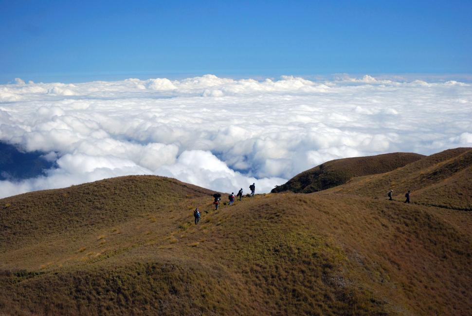 Free Image of Group of People Hiking Up Hill Above Clouds 