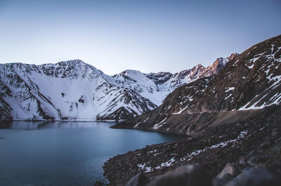 Free Image of Majestic Body of Water Surrounded by Snow Covered Mountains 
