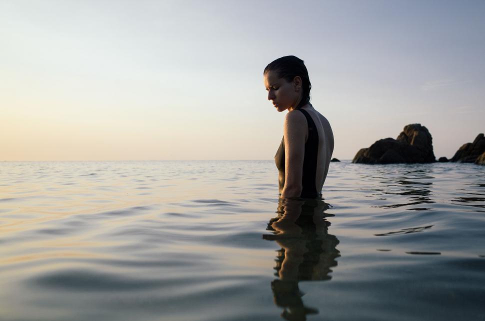 Free Image of Woman Standing in Water Facing Away 