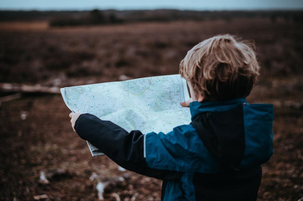 Free Image of Young Boy Studying Map in Field 
