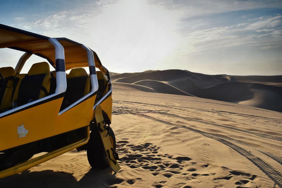Free Image of Yellow Vehicle Driving Through Desert on Sunny Day 