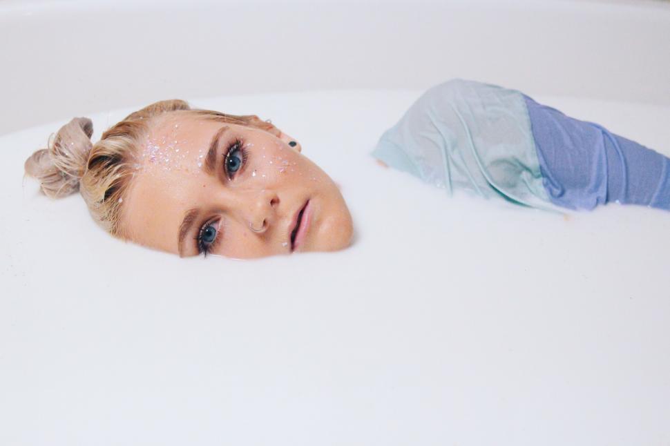 Free Image of Woman Laying in Bathtub Next to Towel 