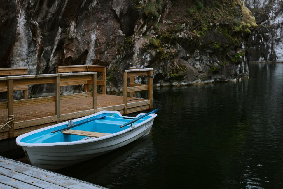 Free Image of Small Boat Tied to Wooden Dock 