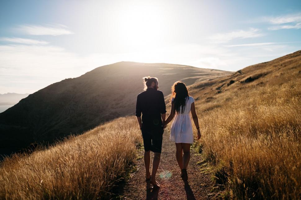 Free Image of A Man and a Woman Walking Down a Trail 