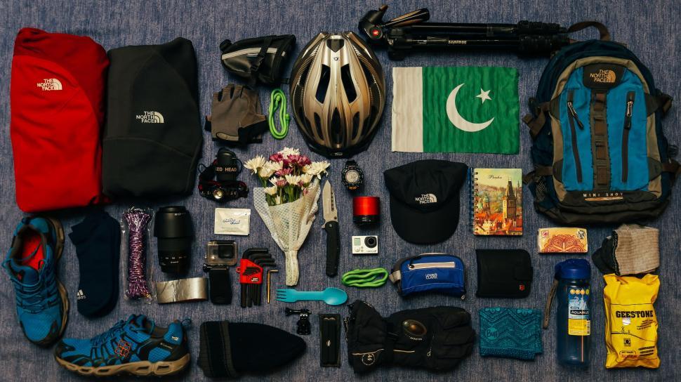 Free Image of The Contents of a Backpack on a Bed 