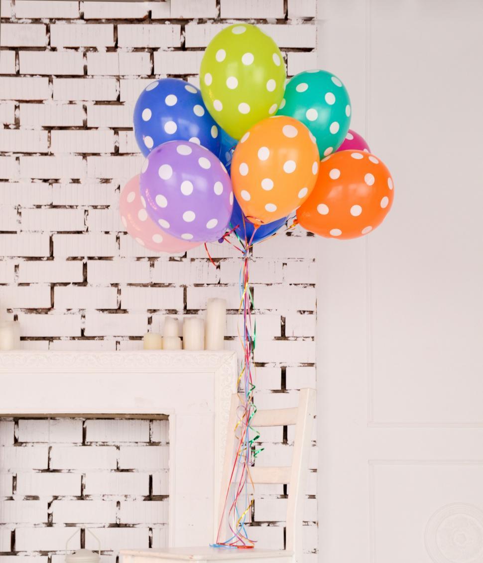 Free Image of Colorful Balloons in Front of Brick Wall 