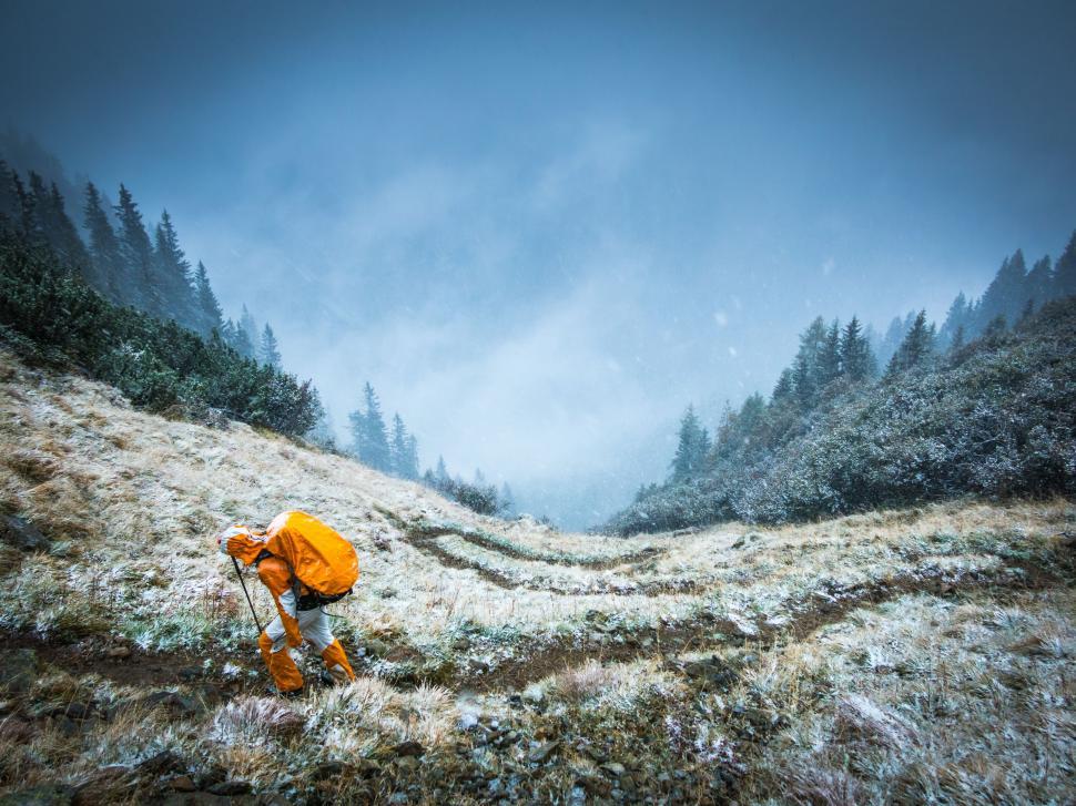 Free Image of Man Hiking Up Snowy Hill 