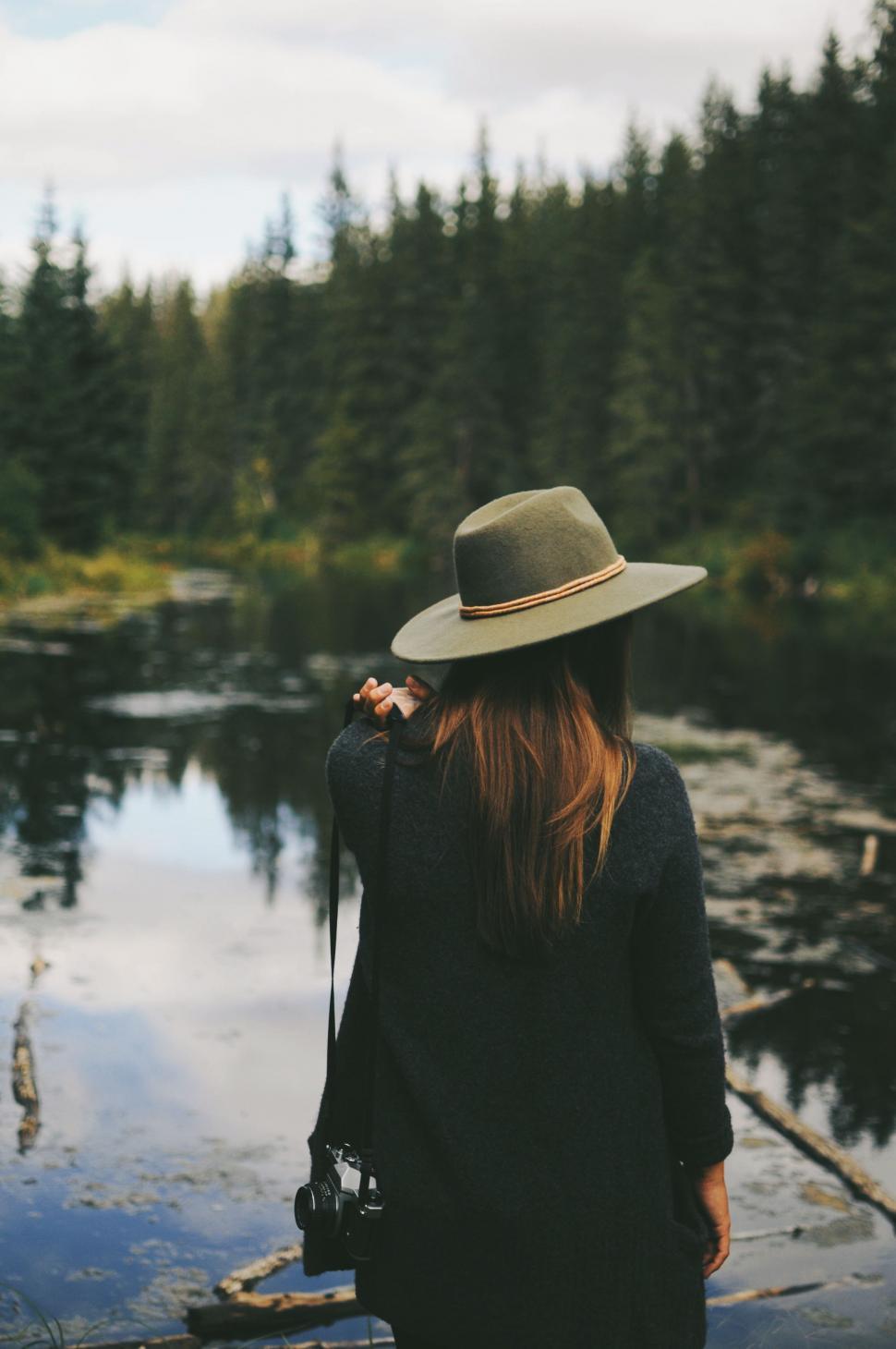 Free Image of Woman in Hat Standing by Lake 