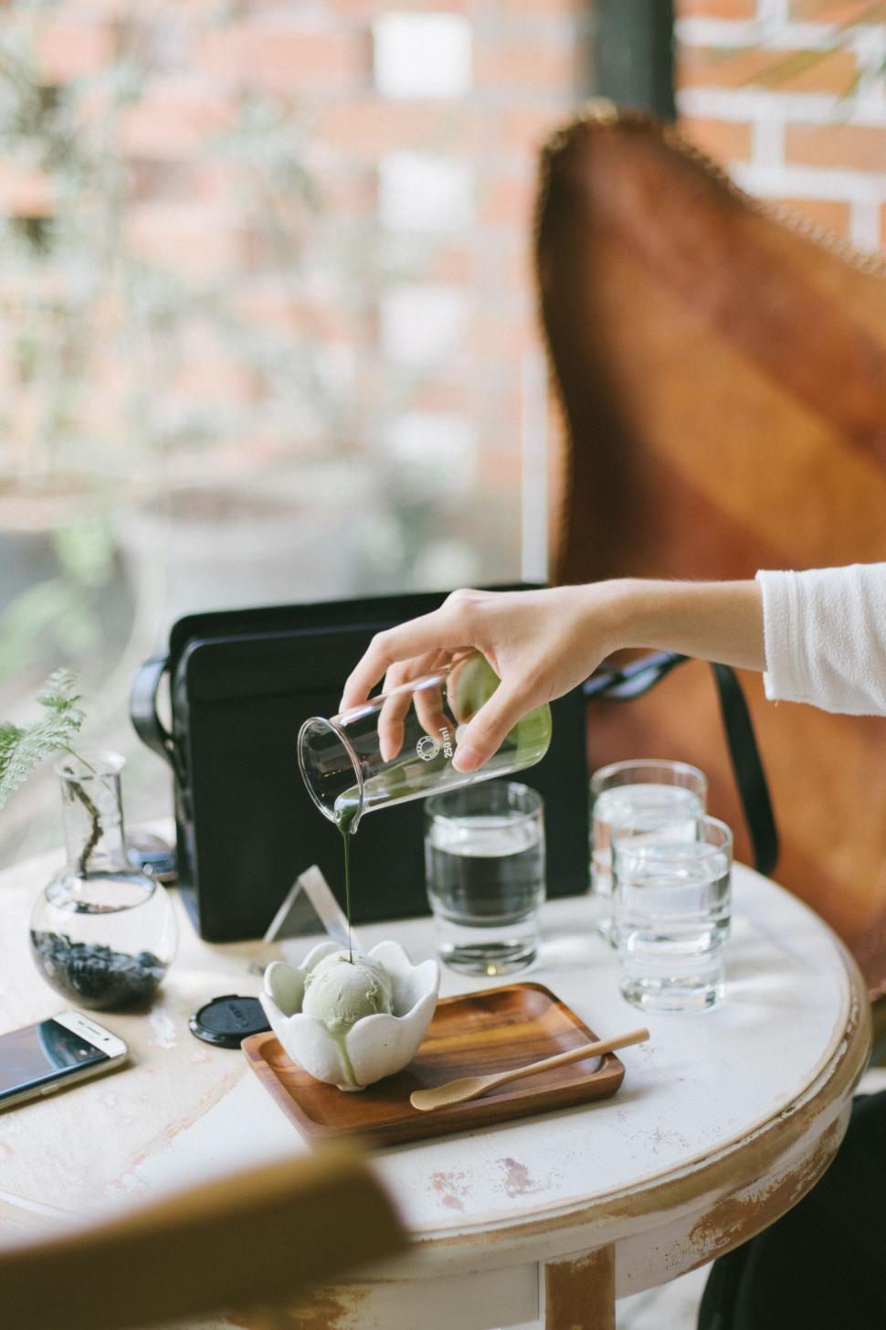 Free Image of Woman Pouring Drink at Table 