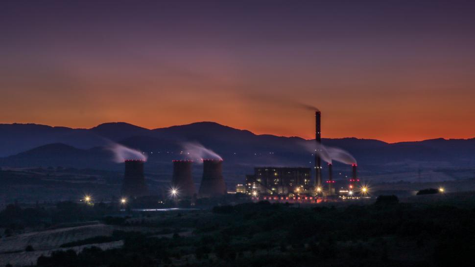 Free Image of Factory With Smoke Stacks at Night With Mountains in Background 