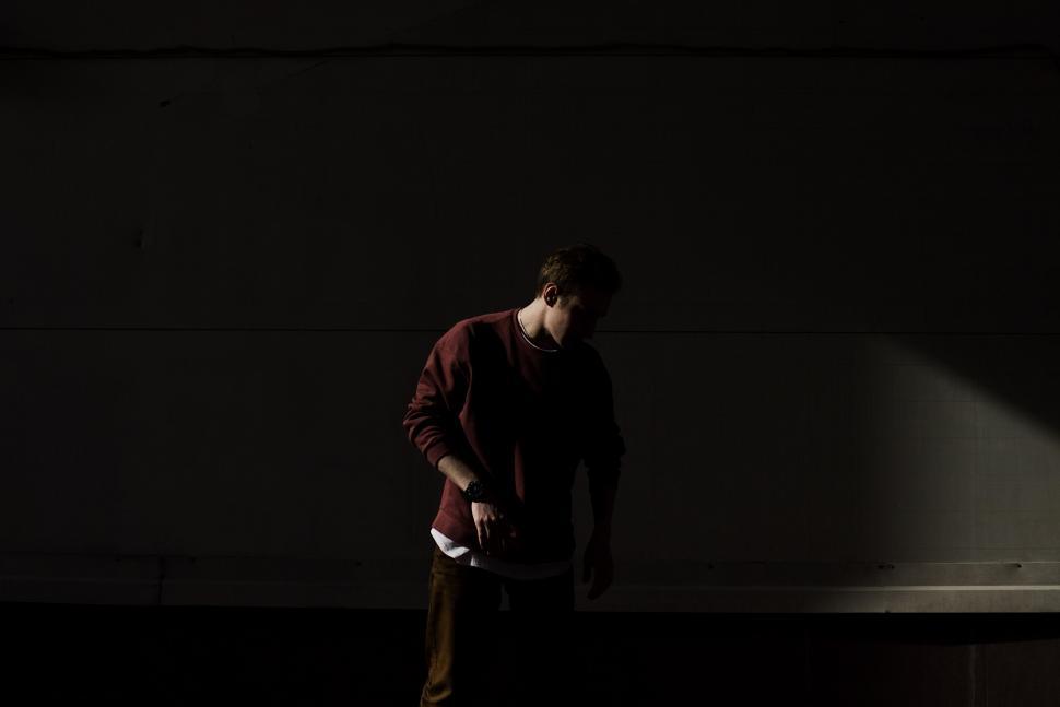 Free Image of Man Standing in Dark With Hands in Pockets 