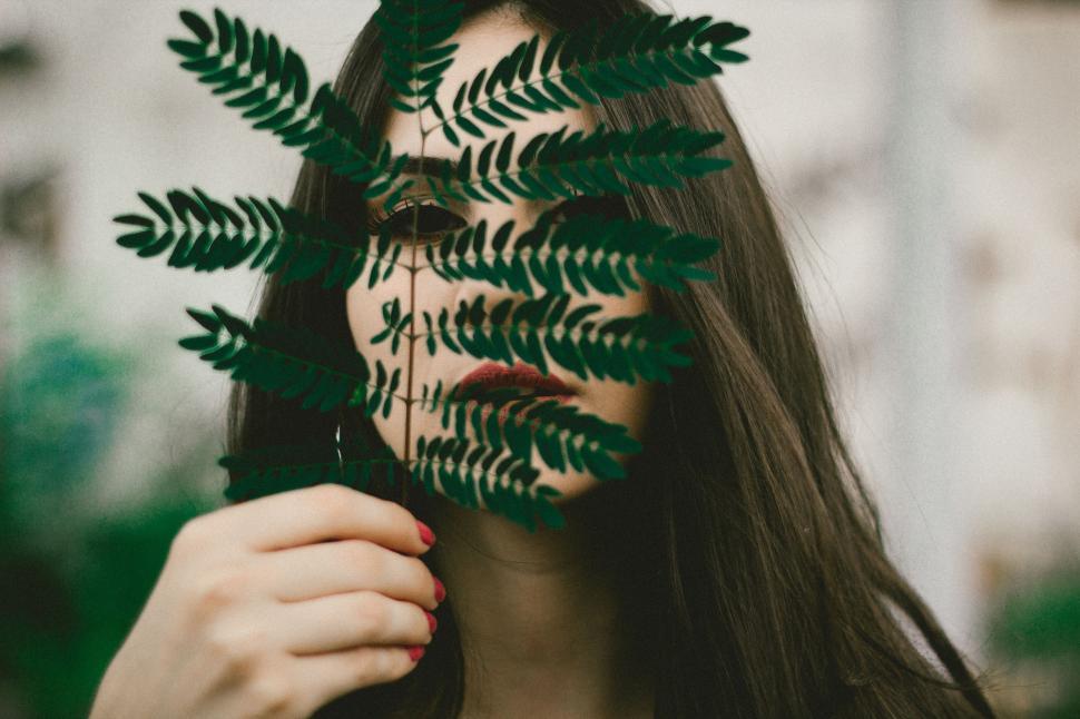 Free Image of Woman Holding Green Leaf Over Face 