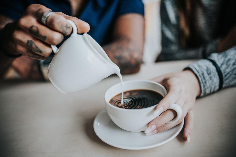 Free Image of Person Pouring Coffee Into a Cup 