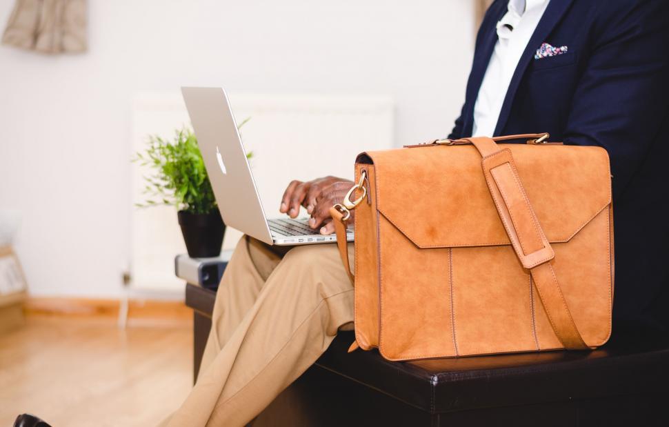 Free Image of Man Sitting on Chair With Briefcase and Laptop 