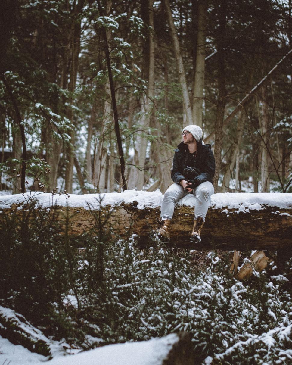 Free Image of Person Sitting on Log in Snow 