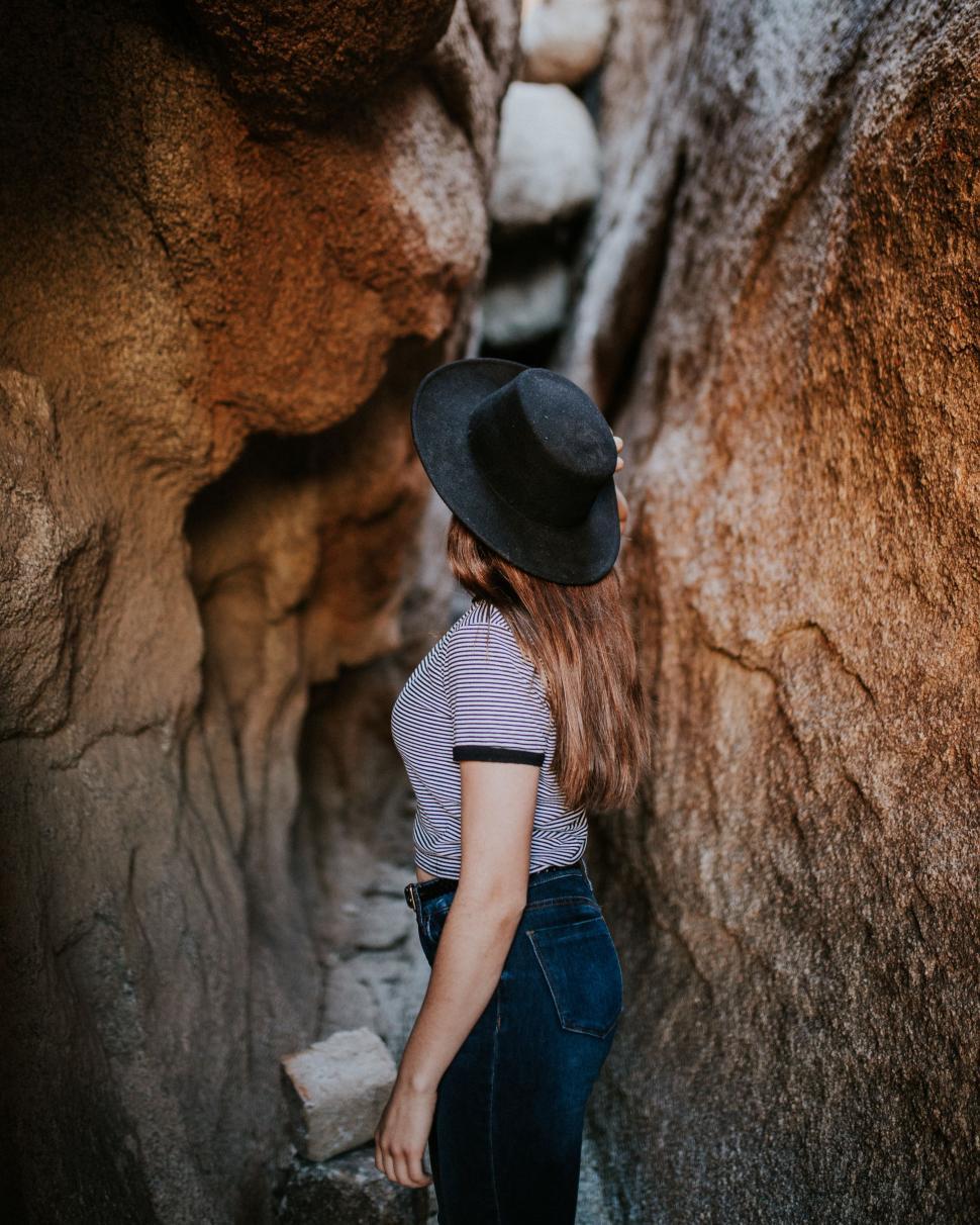 Free Image of Woman Wearing Hat Standing in Cave 