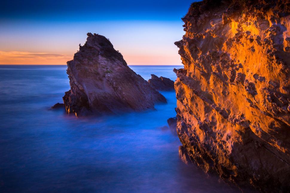 Free Image of Large Rock Protruding From Ocean Waters 