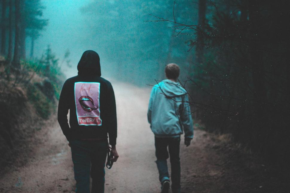 Free Image of Two People Walking Down a Path in the Woods 