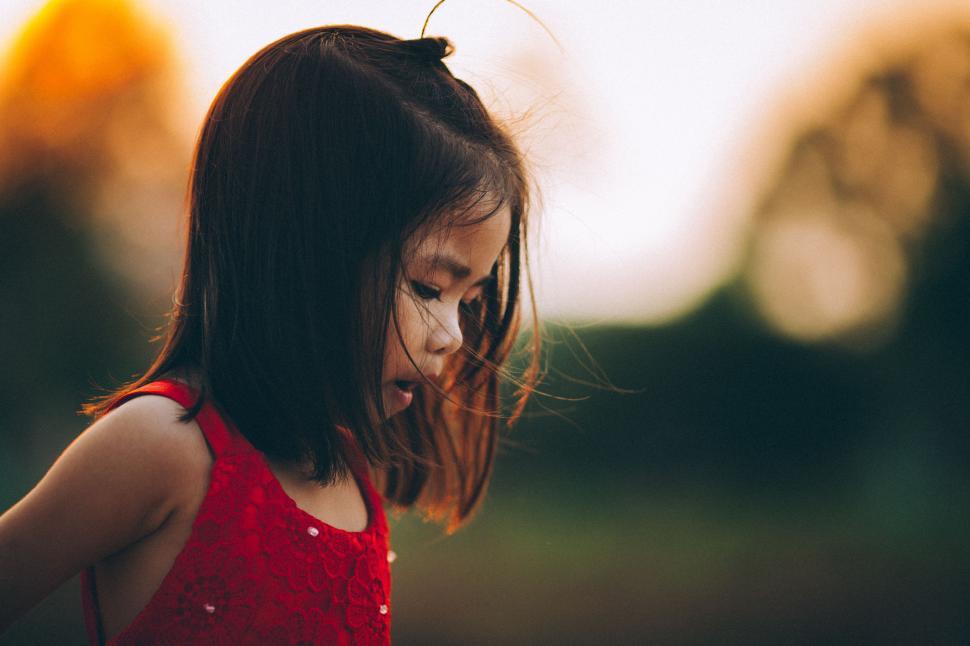 Free Image of Little Girl in Red Dress Looking Down 