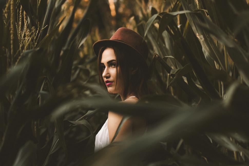 Free Image of Woman Wearing Hat Standing in Corn Field 