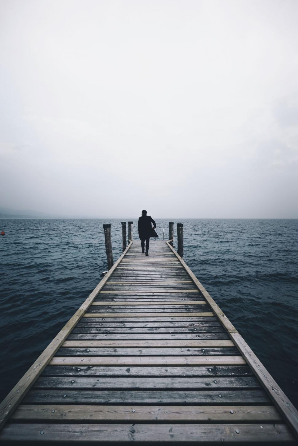 Free Image of Person Standing on Pier in Middle of Ocean 