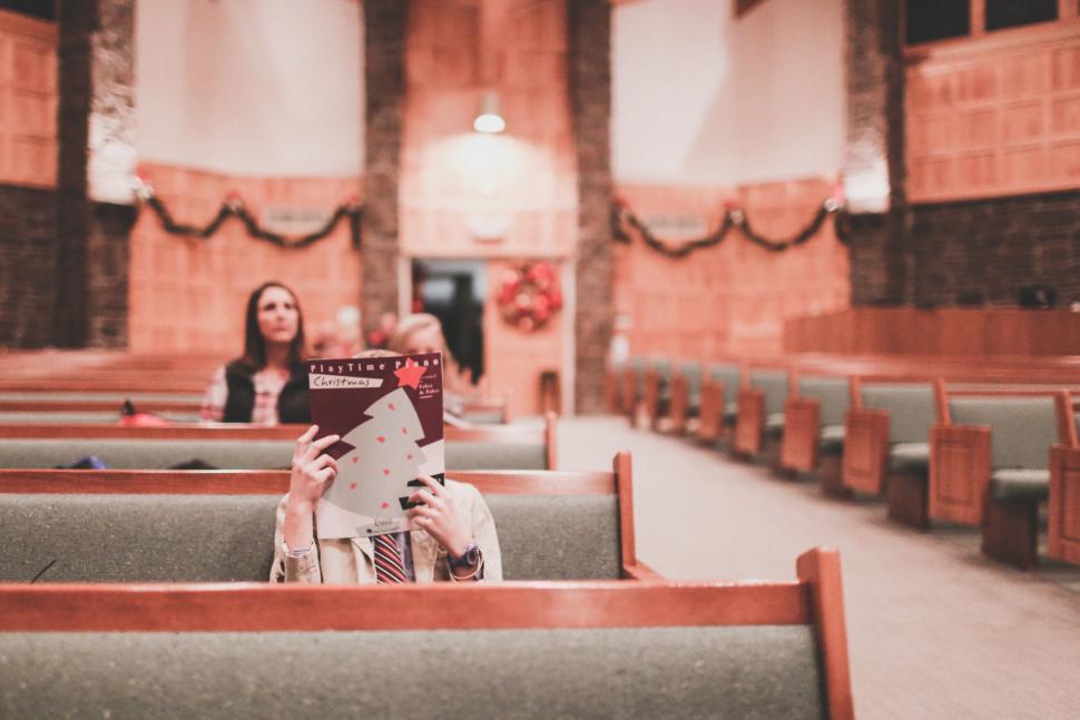 Free Image of Two Women Reading a Book in Church Pews 