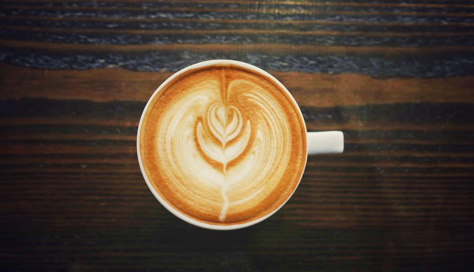 Free Image of A Cappuccino With a Flower on Wooden Table 