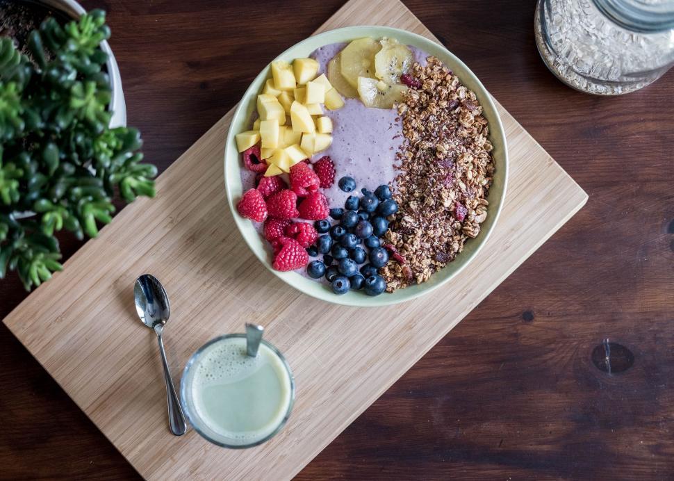 Free Image of Bowl of Cereal, Fruit, and Yogurt on Cutting Board 