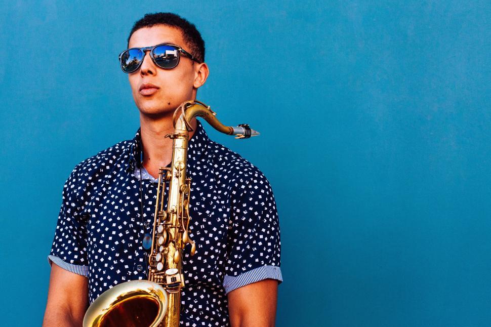 Free Image of Man Wearing Sunglasses Holding Saxophone 