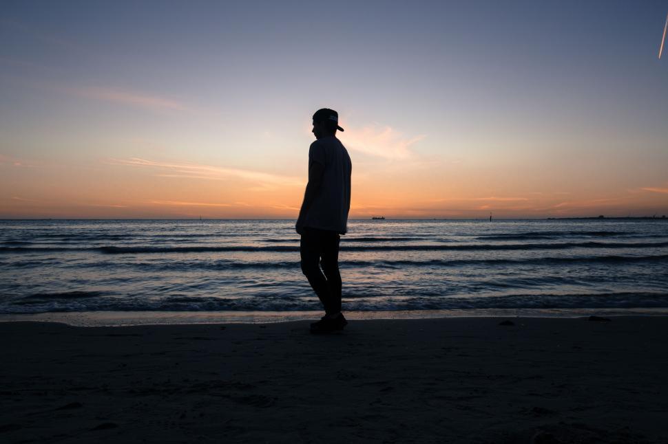 Free Image of Man Standing on Top of Beach by Ocean 