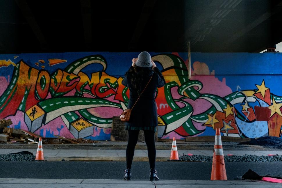 Free Image of Person Standing in Front of Graffiti Covered Wall 