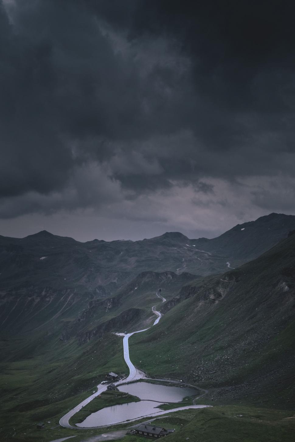 Free Image of A Winding Road in the Mountains Under a Cloudy Sky 