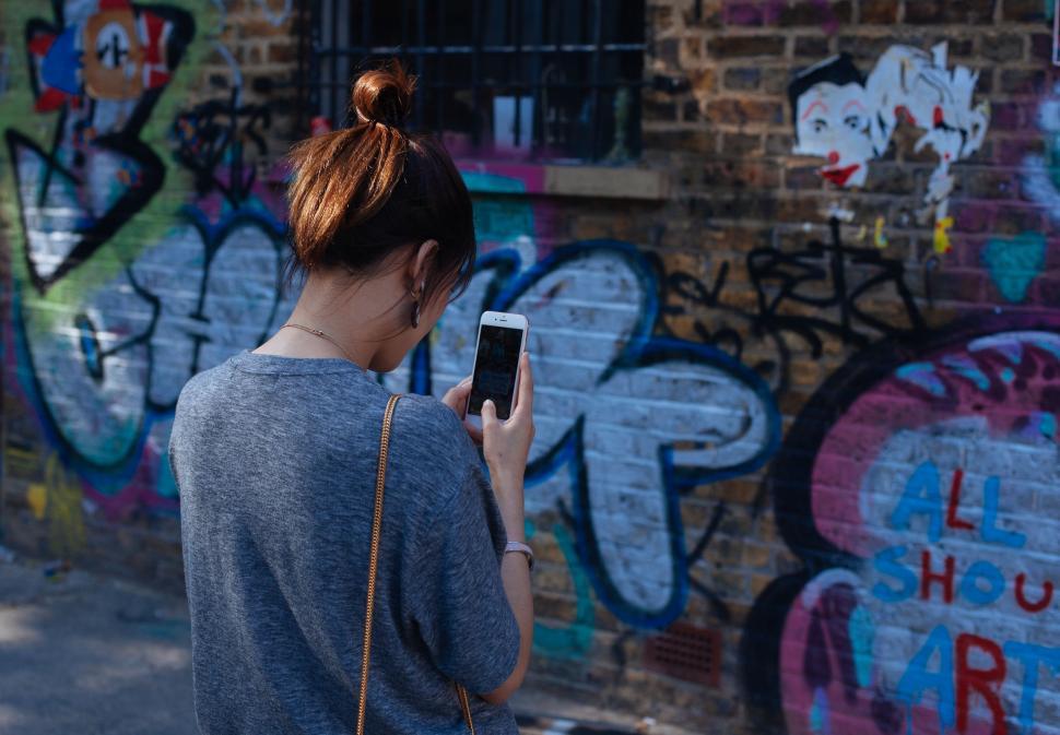 Free Image of Woman Standing in Front of Graffiti-Covered Wall 