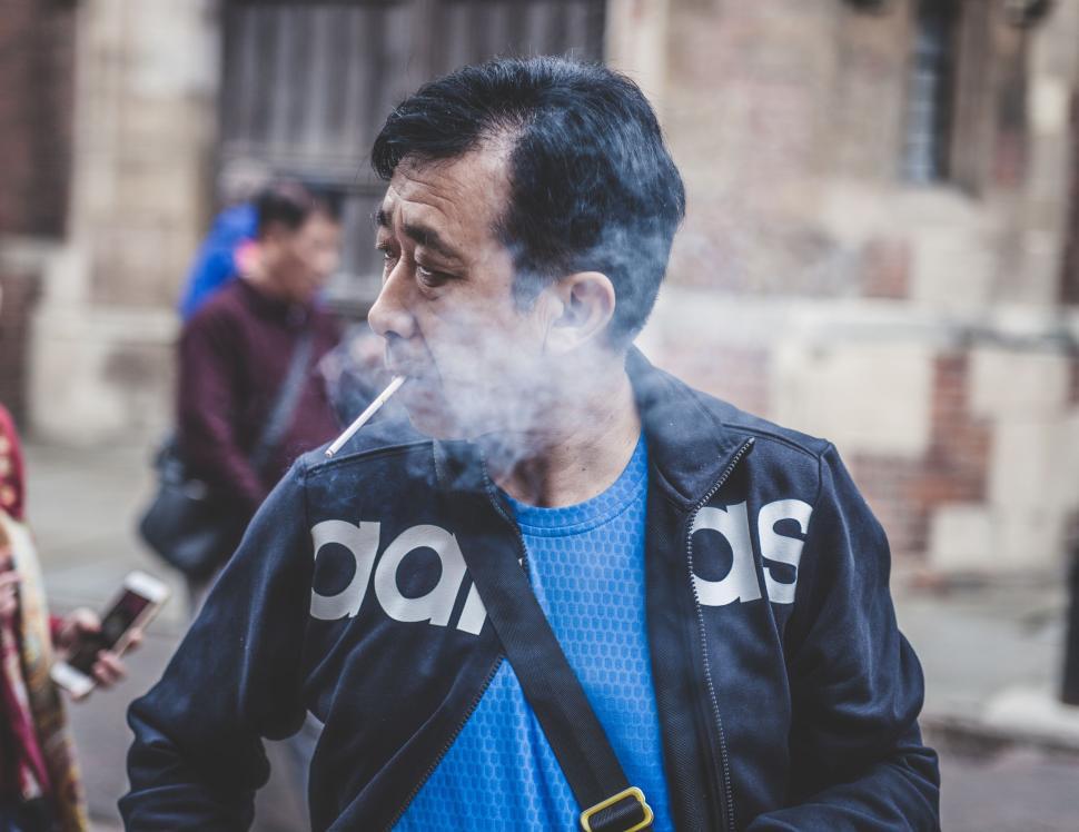 Free Image of Man Smoking Cigarette on City Street 