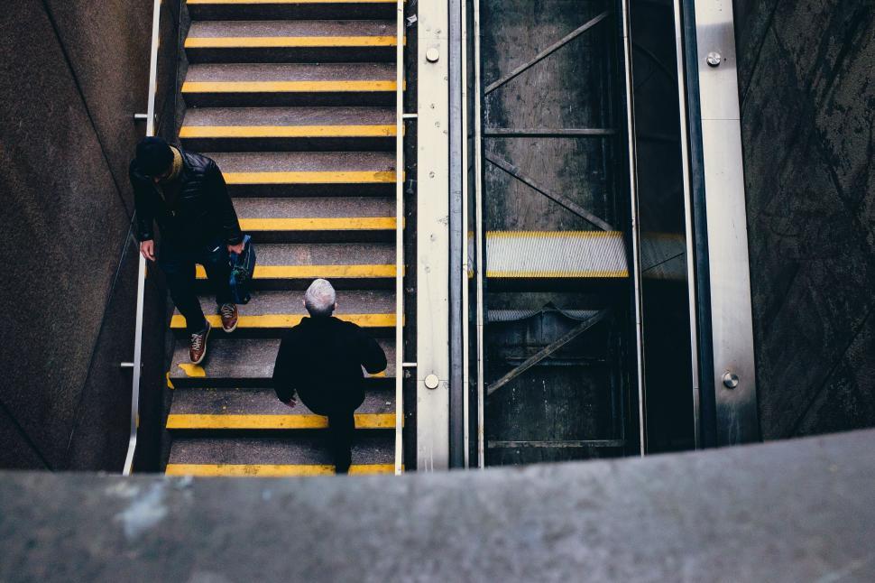 Free Image of Two People Walking Up a Flight of Stairs 