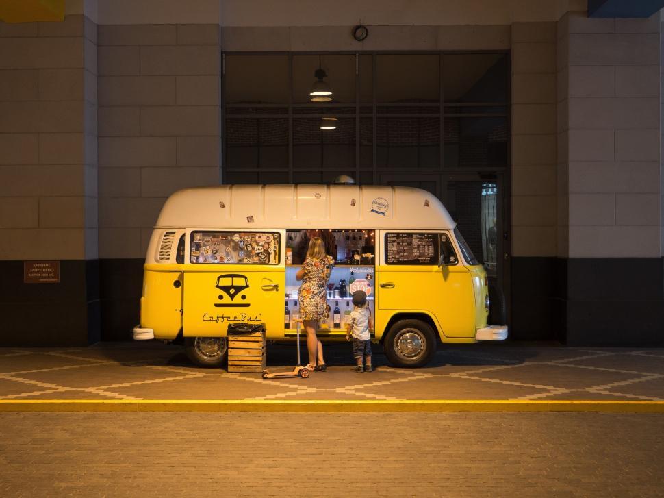 Free Image of Yellow and White Bus Parked in Front of a Building 