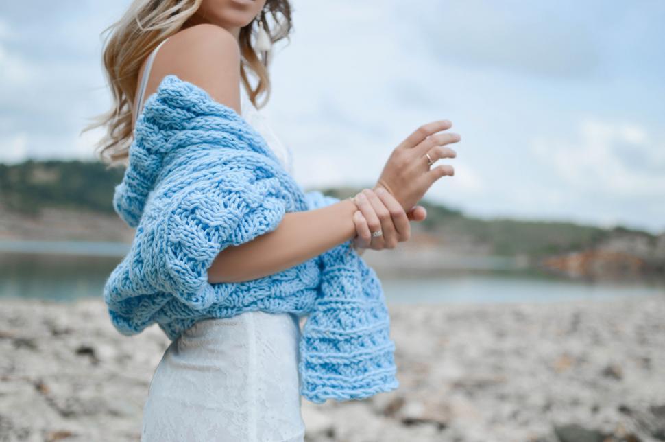 Free Image of Woman Standing on Beach Wearing Blue Sweater 