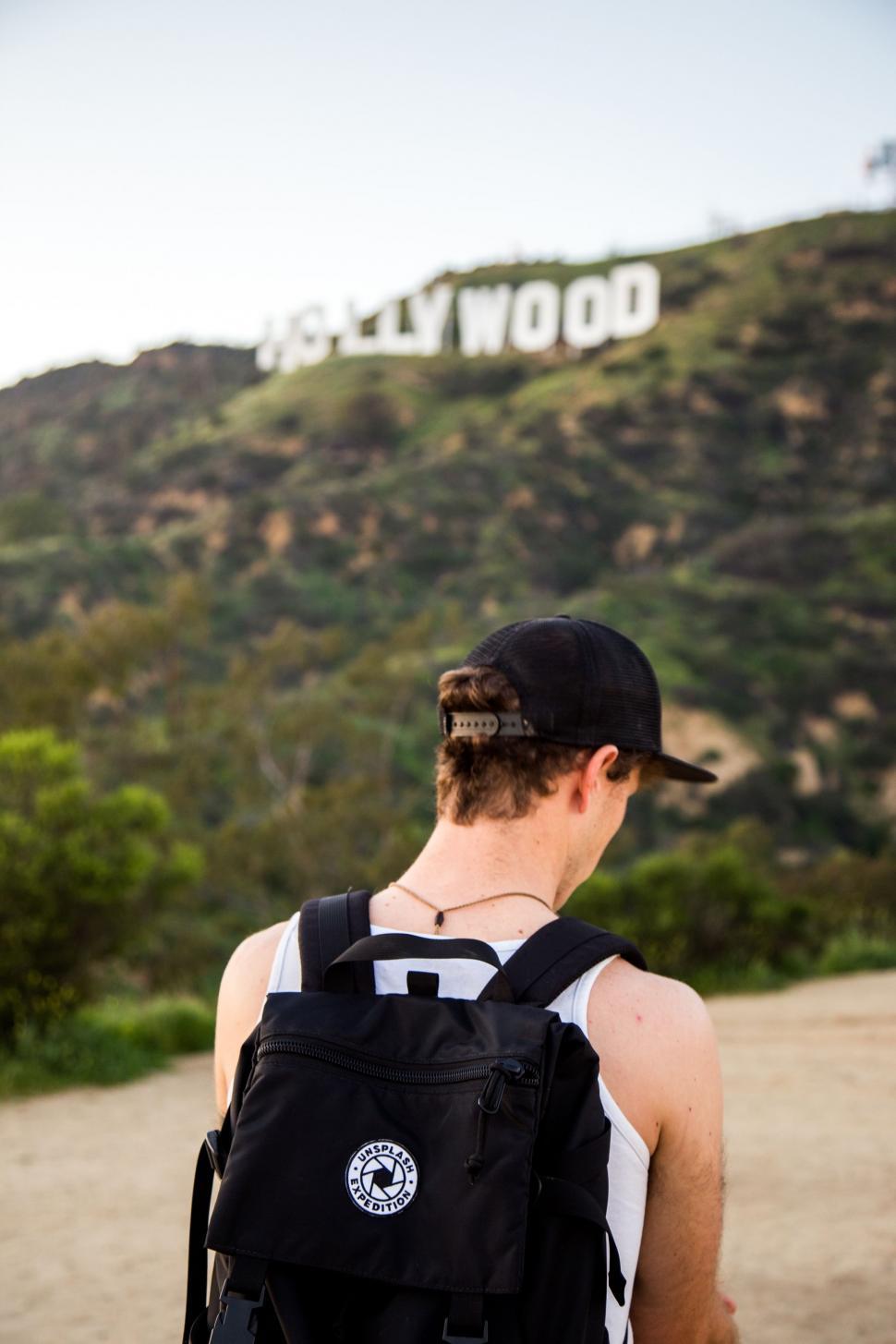 Free Image of Man With Backpack Looking at the Hollywood Sign 