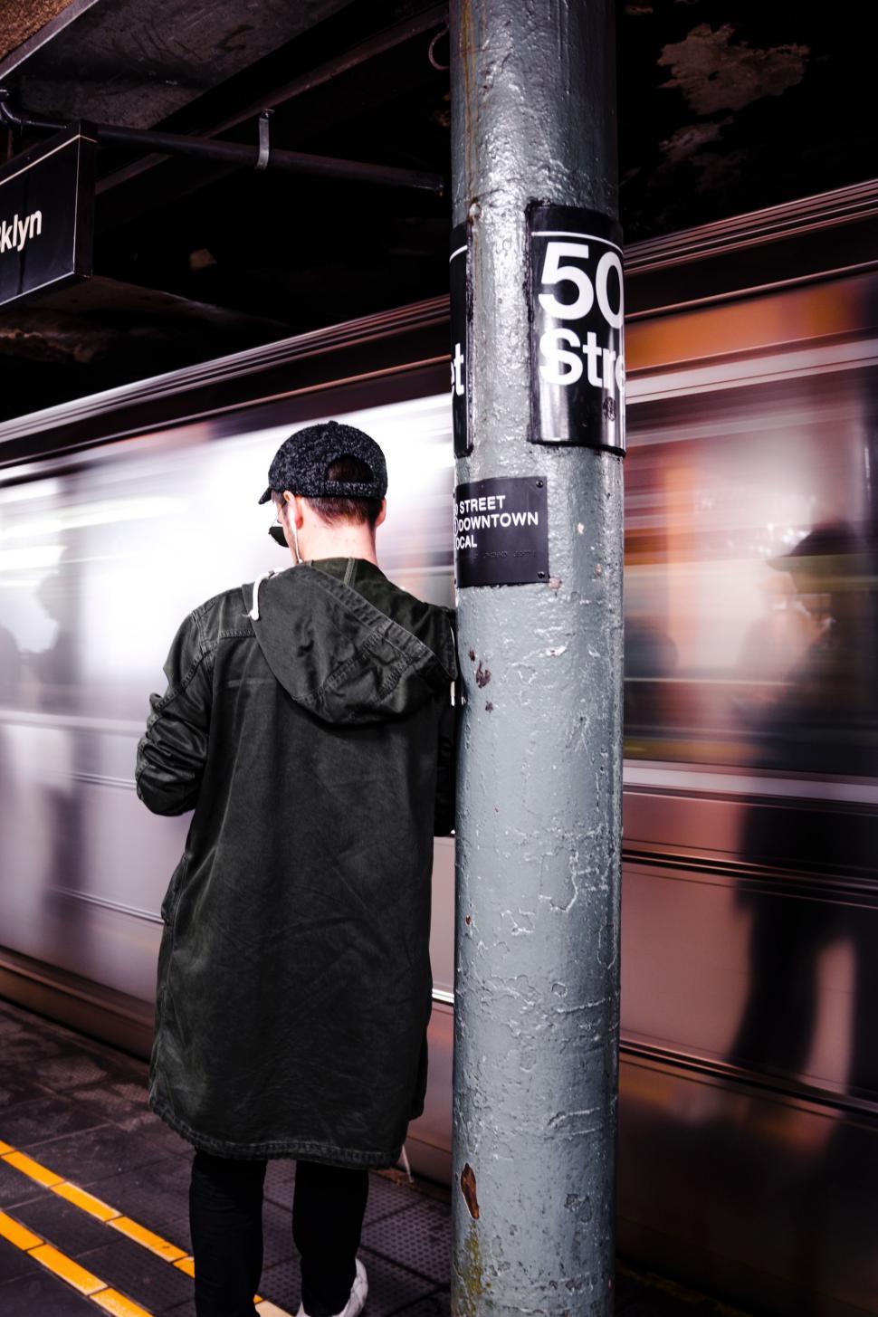Free Image of Man Standing Next to Pole Near Train 
