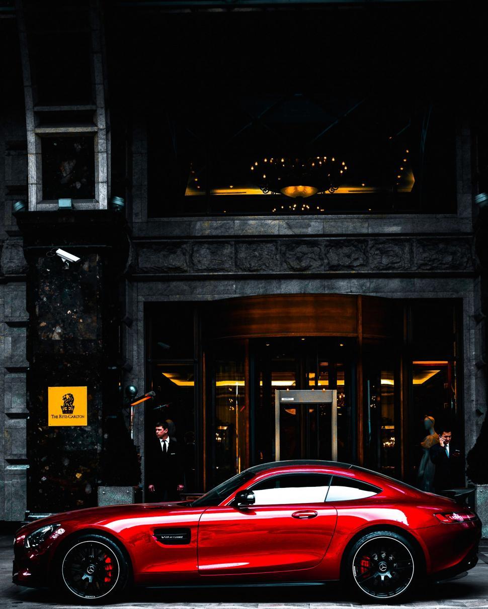 Free Image of Red Sports Car Parked in Front of Building 