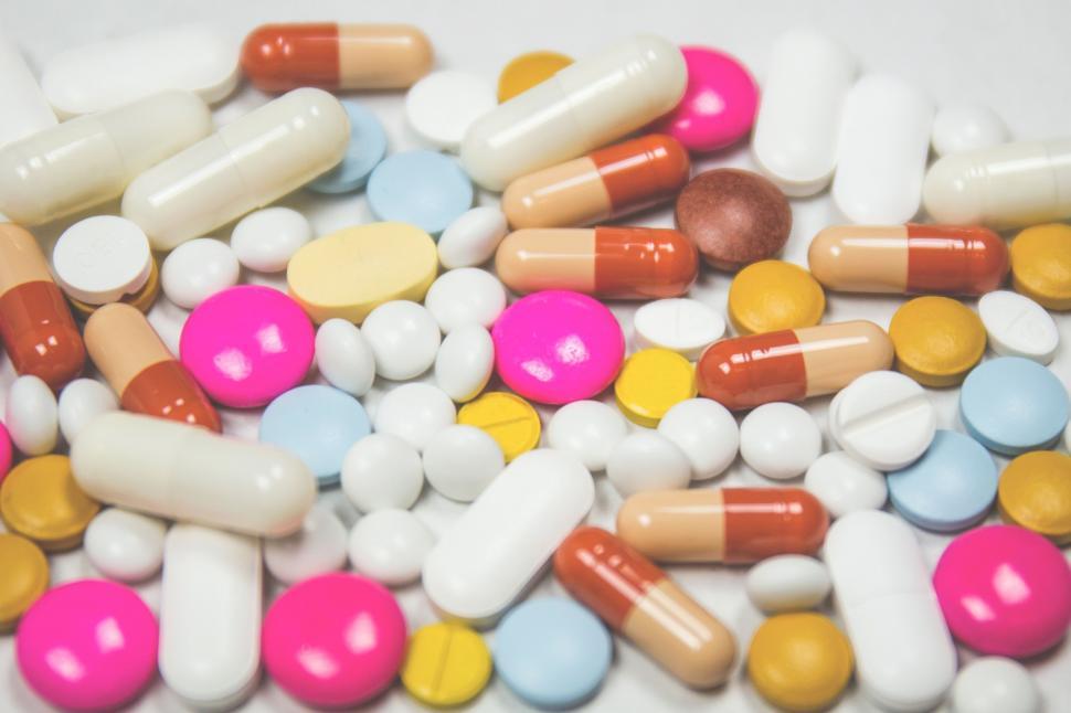 Free Image of A Pile of Colorful Pills on a White Surface 