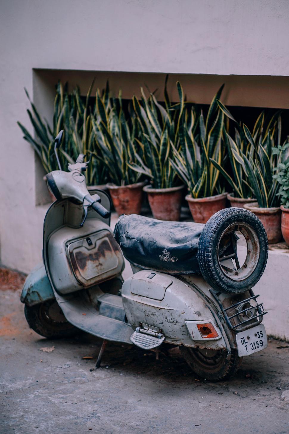 Free Image of Motor Scooter Parked in Front of a House 