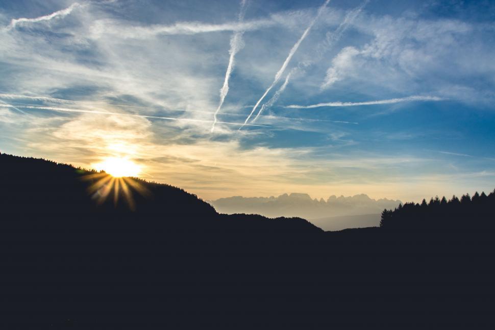 Free Image of Sun Setting Over Mountains and Trees 