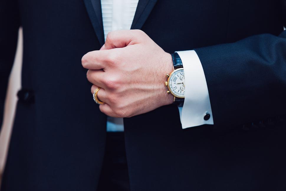 Free Image of Person in Suit Holding Watch 