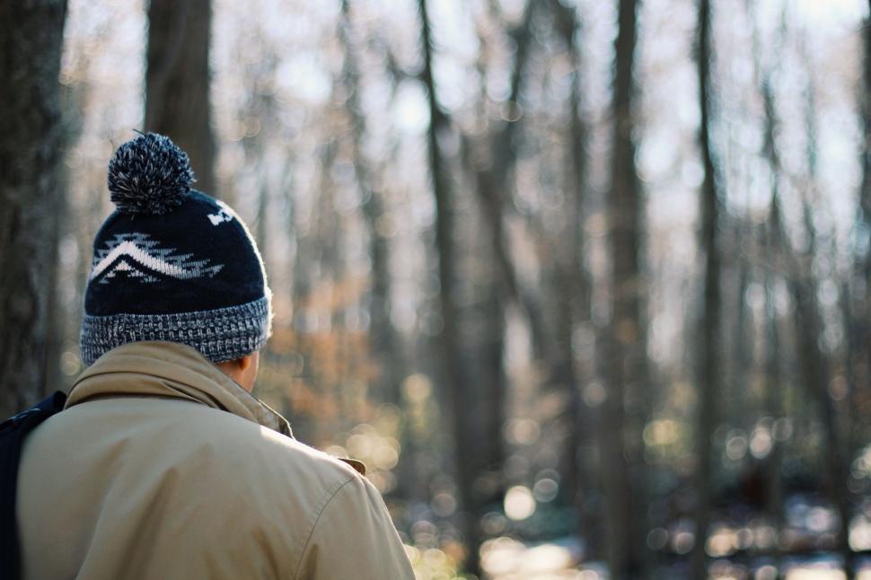 Free Image of Man Walking Through Forest in Beanie 