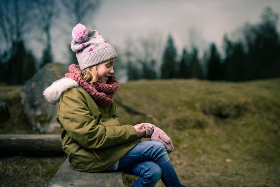 Free Image of Woman Sitting on a Bench With Hat and Scarf 