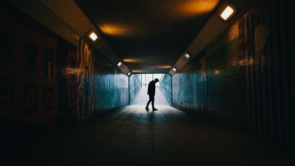 Free Image of Person Standing in Dark Tunnel With Light at End 
