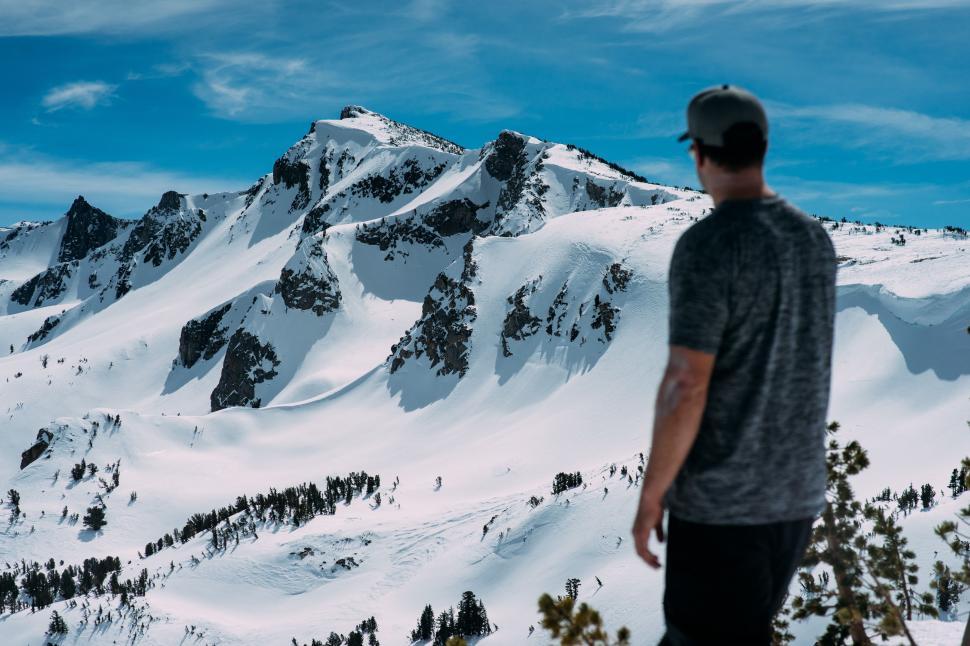 Free Image of Man Standing on Top of Snow Covered Mountain 